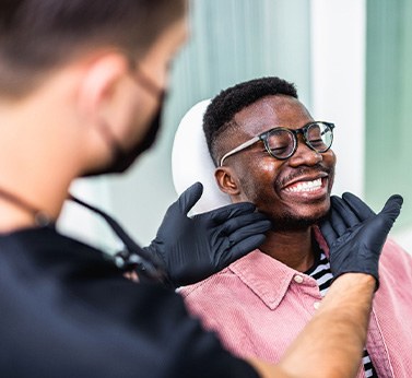 Dentist looking at smiling patients teeth