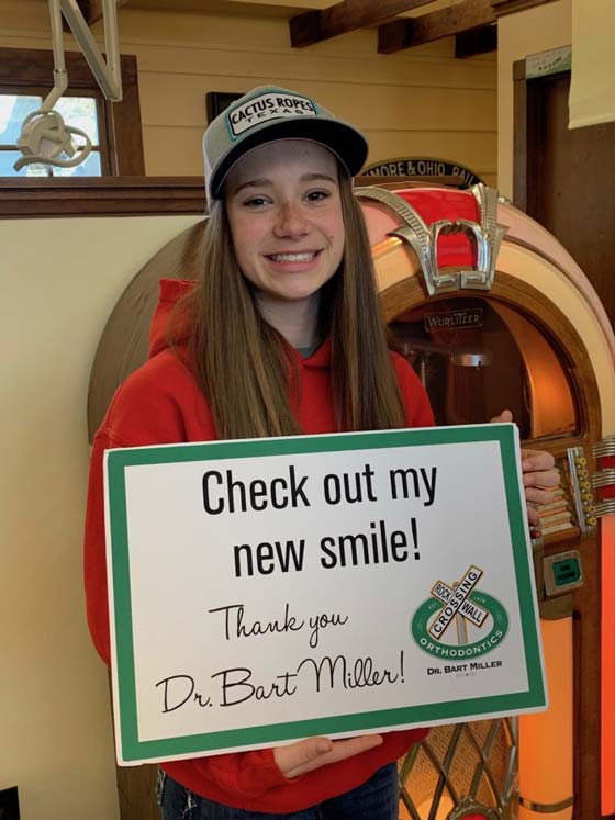 Young female patient smiling with New Smile Sign